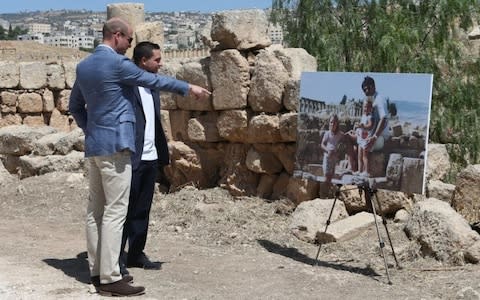 The Duke of Cambridge (left) and Crown Prince Hussein of Jordan look at a photo of the Duchess of Cambridge as a child, when she was photographed with her family at the same spot of the Jerash archaeological site in Jordan - Credit: Ian Vogler/PA