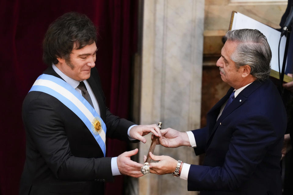 Argentina's incoming President Javier Milei receives the presidential cane from outgoing President Alberto Fernandez at the Congress in Buenos Aires, Argentina, Sunday, Dec. 10, 2023. (AP Photo/Natacha Pisarenko)