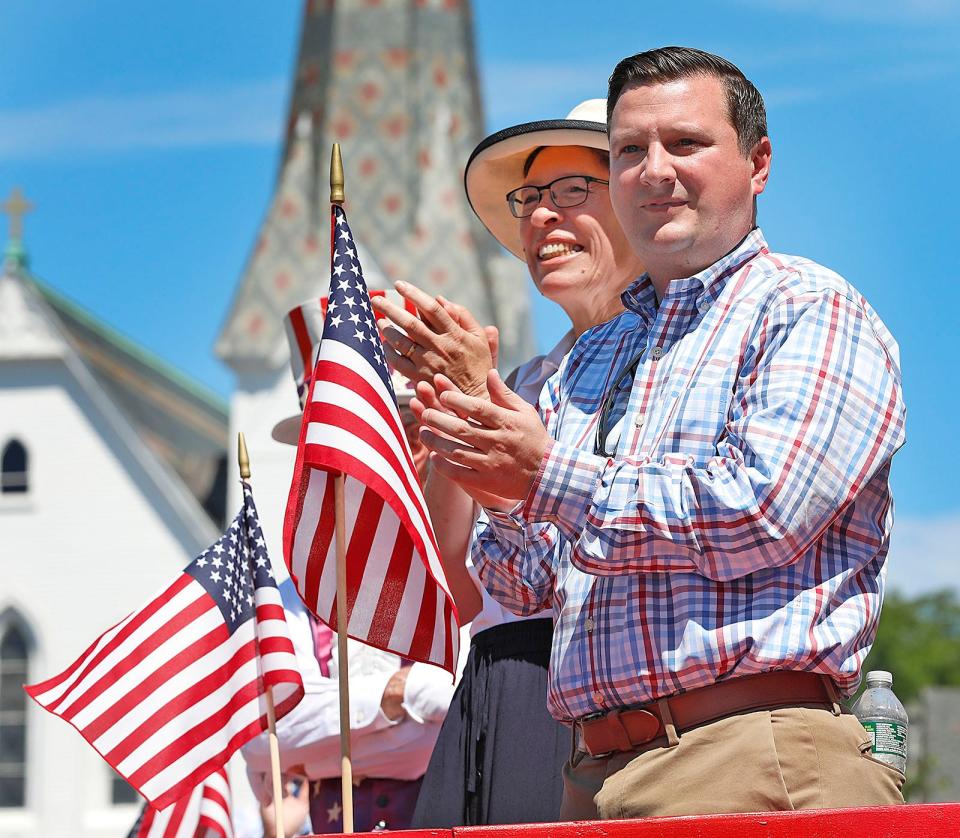 State Rep. Joan Meschino and state Sen. Patrick O'Connor applaud parade units from the viewing stand during the annual Fourth of July parade in Hingham on Monday, July 4, 2022.