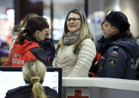 A woman reacts next to Russian Emergencies Ministry members at Pulkovo airport in St. Petersburg, Russia, October 31, 2015. REUTERS/Peter Kovalev