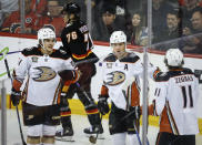 Anaheim Ducks defenceman Cam Fowler (4) celebrates his goal with teammates as Calgary Flames forward Martin Pospisil (76) skates away during the third period of an NHL hockey game Tuesday, April 2, 2024, in Calgary, Alberta. (Jeff McIntosh/The Canadian Press via AP)