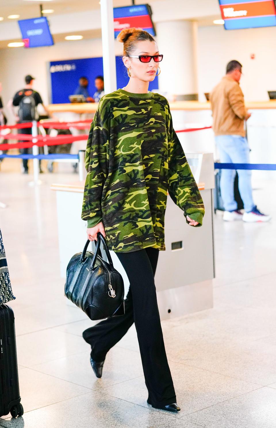 <h1 class="title">Bella Hadid At JFK Airport In New York Wearing Camo</h1><cite class="credit">Photo: Splash News</cite>