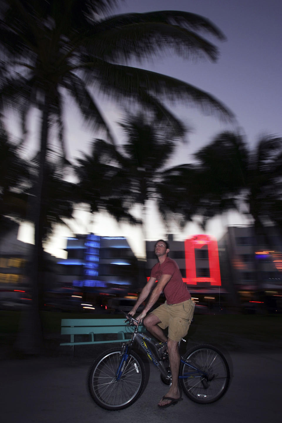 FILE - In this Jan. 31, 2007 file photo, a man rides a bike in the South Beach area of Miami Beach, Fla. The bike scene in Miami has taken off in recent years, and since parking is expensive and can be hard to find, riding a bike can be a great way to get around. (AP Photo/Carlo Allegri, File)