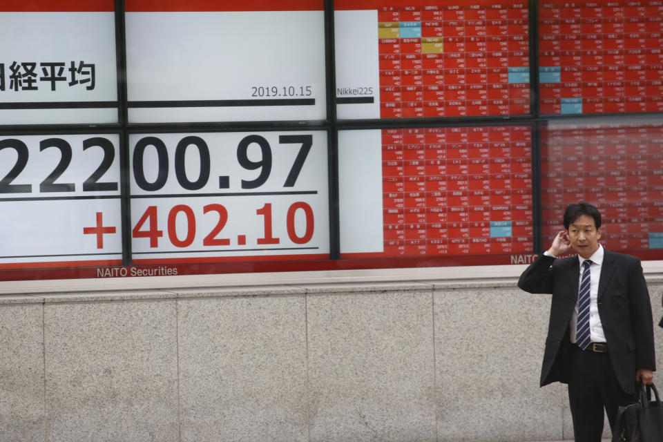 A man stands in front of an electronic stock board of a securities firm in Tokyo, Tuesday, Oct. 15, 2019. Shares are mixed in Asia after a wobbly day of trading on Wall Street. Japan’s Nikkei 225 index jumped 1.8% as it reopened from a public holiday and investors caught up on the news of a preliminary trade deal between China and the U.S. (AP Photo/Koji Sasahara)