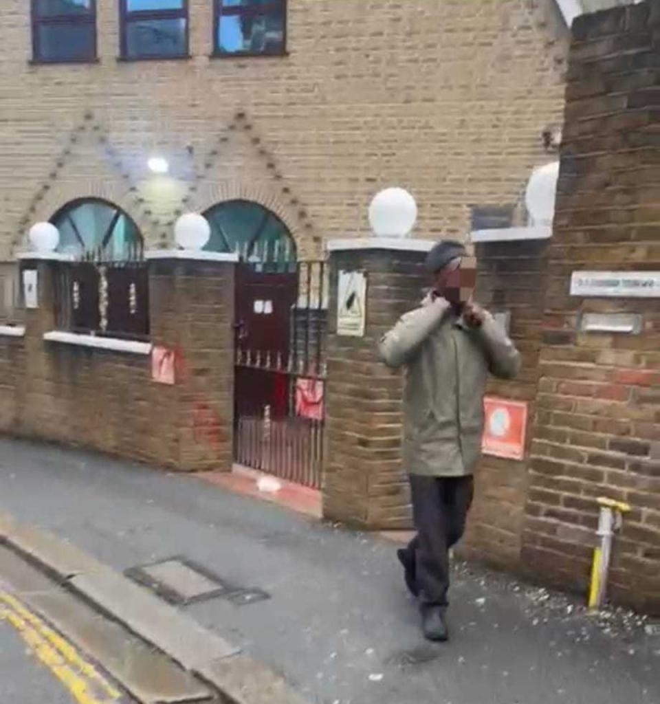 A worshipper walks away from the vandalised Acton Central Mosque (Supplied)