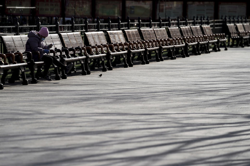 A woman wearing a face mask to help curb the spread of the coronavirus takes a rest on the bench at the Forbidden City in Beijing, Sunday, Jan. 10, 2021. More than 360 people have tested positive in a growing COVID-19 outbreak south of Beijing in neighboring Hebei province. (AP Photo/Andy Wong)