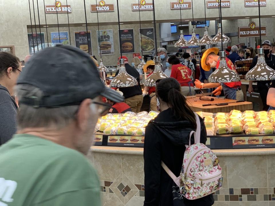 Customers check out the Texas Round Up area at the new Buc-ee's in Daytona Beach on opening day March 22, 2021.  The mega travel convenience center serves a wide array of to-go foods including Texas barbecue sandwiches, pulled pork, smoked turkey sandwiches, tacos and sausages as well as fresh baked goods and desserts.
