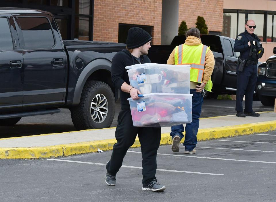 A man carries personal belongings from the APM Inn and Suites along Dual Highway Monday after city officials condemned the building.