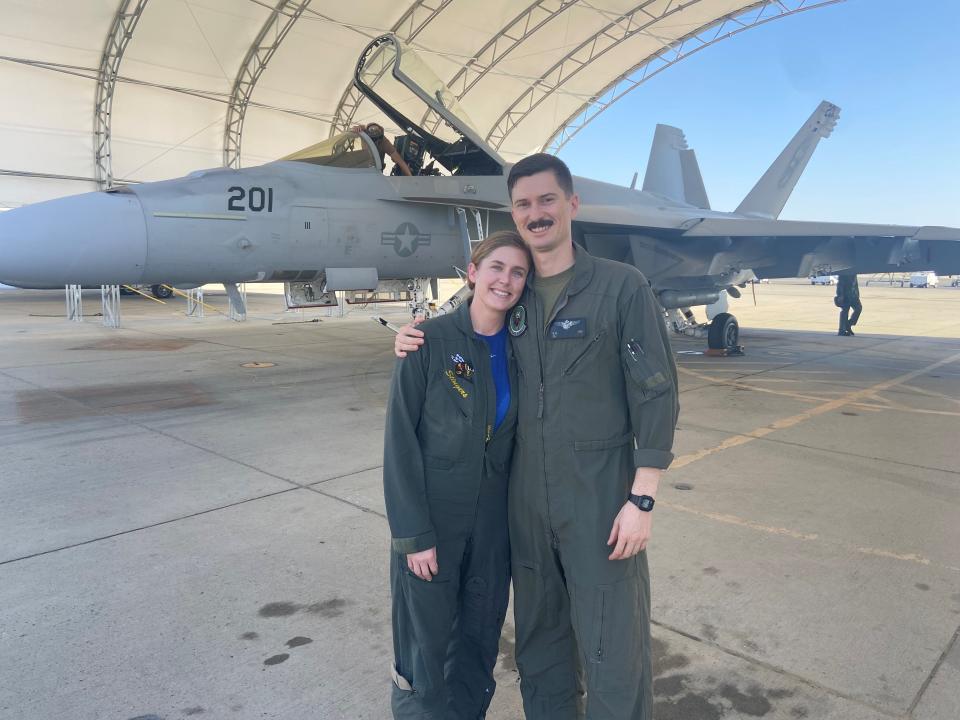 Arielle Ash, left and husband Brett Ash, pose for a photo in front of a fighter jet at the Naval Air Station Lemoore in Hanford, Calif., in this undated photo. Both are fighter pilots and flight instructors in the military.