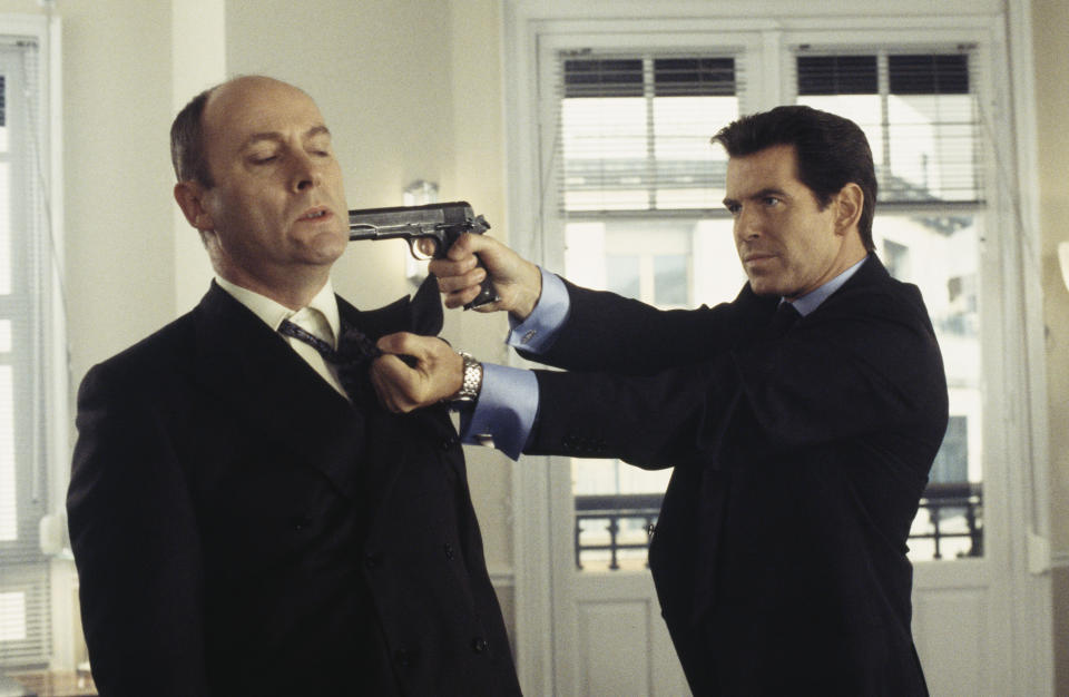 Irish actor Pierce Brosnan as 007 in the James Bond film 'The World Is Not Enough', 1999. Here he threatens Swiss banker Lachaise, played by English actor Patrick Malahide, with a Colt M1911A1 semi-automatic pistol. (Photo by Keith Hamshere/Getty Images) 