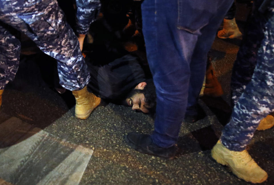 Riot police arrest a protester during an anti-government protest in Beirut, Lebanon, Wednesday, Dec. 4, 2019. Protesters have been holding demonstrations since Oct. 17 demanding an end to corruption and mismanagement by the political elite that has ruled the country for three decades. (AP Photo/Bilal Hussein)