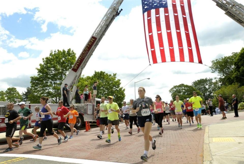 The Worcester Firefighters 6K starts and finishes under an American flag draped between two Worcester Fire ladder trucks.