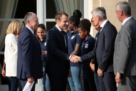 French President Emmanuel Macron (C) shakes hands with Lyon's football team staff as Olympique Lyon's soccer club head Aulas (L) looks on during a ceremony at the Elysee Palace in Paris, France, June 20, 2017 to celebrate the victory of Lyon's football team during the UEFA Women's Champions League. Picture taken June 20, 2017. REUTERS/Geoffroy van der Hasselt/Pool