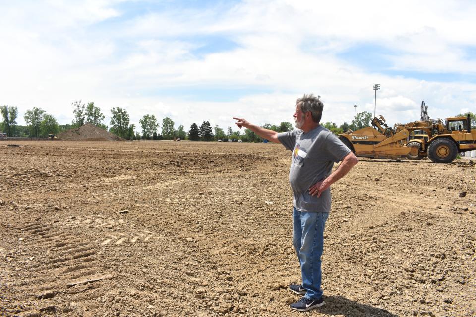 Tim Bakewell, who lives on Canterbury Street in Adrian, points across a field of dirt Friday to the area where Adrian College's planned sports dome will be built. The dome has become an issue for the college's neighbors, like Bakewell, over the past several weeks. The apex of the dome is expected to be 90 feet high.