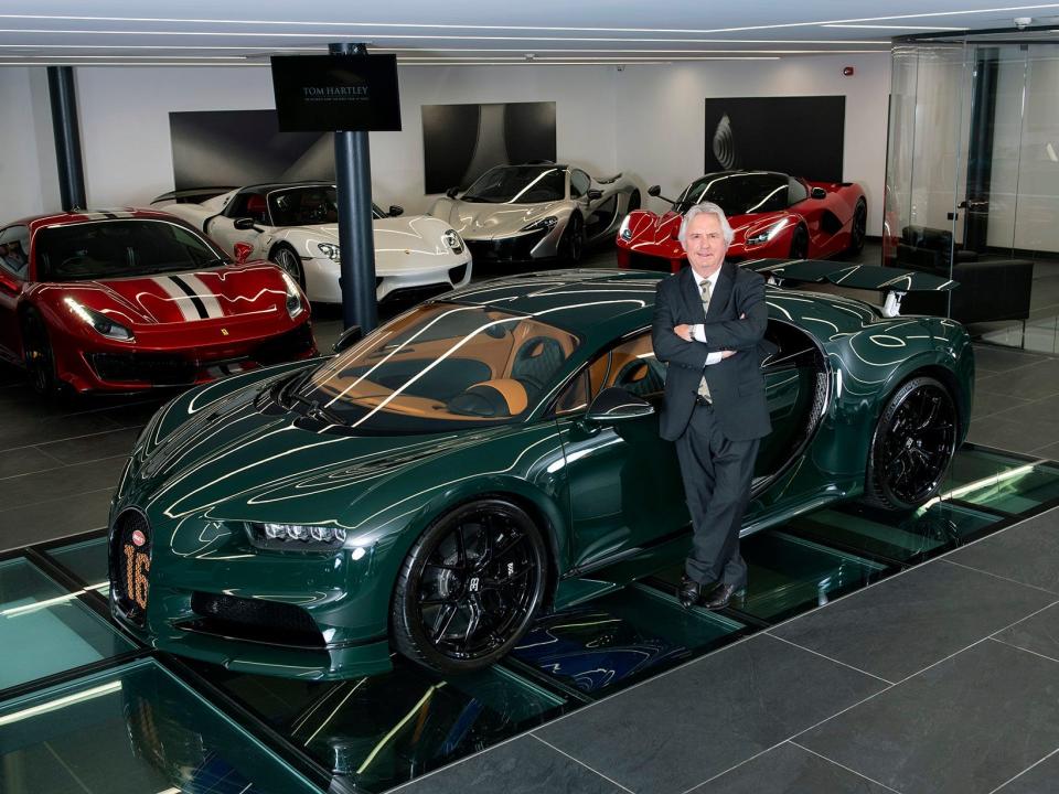 man standing next to a luxury car