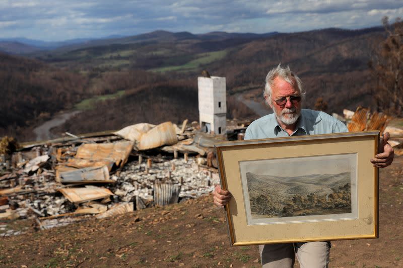 Donald Graham, 68, poses with a lithograph by Eugene von Guerard of the Buchan and Snowy Rivers, which Graham saved from a bushfire as he took shelter in his bunker with his wife Bron, as their home was destroyed by bushfires in Buchan, Victoria, Australia