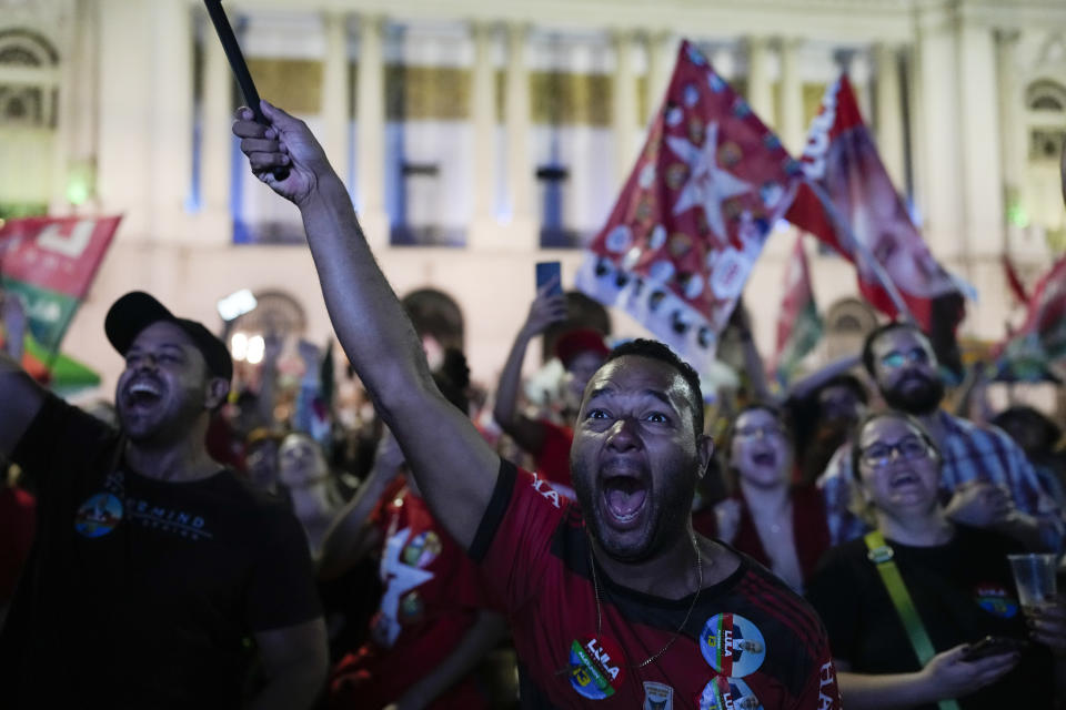 Followers of former Brazilian President Luiz Inacio Lula da Silva, who is running for president again, react to partial results after general election polls closed in Rio de Janeiro, Brazil, Sunday, Oct. 2, 2022. (AP Photo/Silvia Izquierdo)