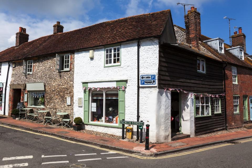 alfriston village in east sussex, england picturesque shops and tearoom on north street one person inside shop doorway