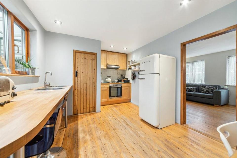 Inside the house is less colourful than the outside, with pale walls and wooden floors (Rightmove)