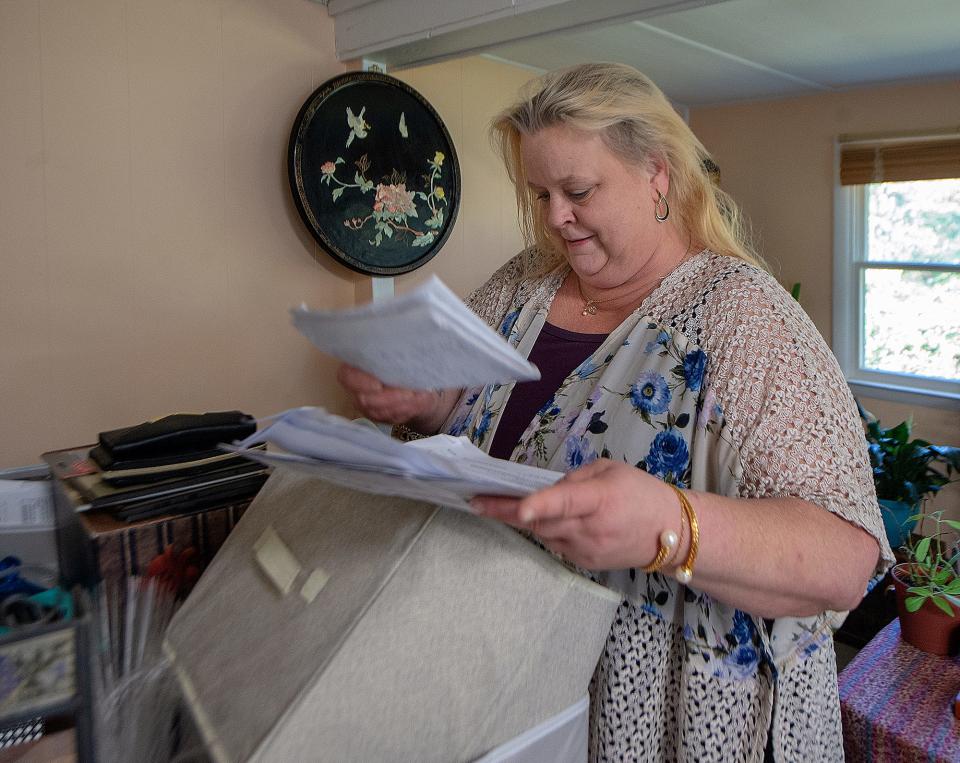 Karen McDonald sorts through papers inside her mobile home in Falls Township, on Monday, Nov. 8, 2021.