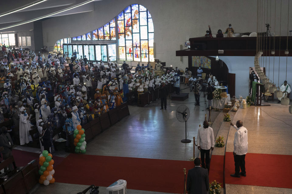 Former Ivorian president Laurent Gbagbo, right bottom, waves to the people during a Mass at the Saint Paul's cathedral in Abidjan, Ivory Coast, Sunday, June 20, 2021. Gbagbo, who has returned to the country after nearly a decade, was extradited to the International Criminal Court at The Hague in 2011 and spent eight years awaiting trial on war crimes charges. A judge acquitted him in 2019, saying prosecutors had failed to prove their case. (AP Photo/Leo Correa)