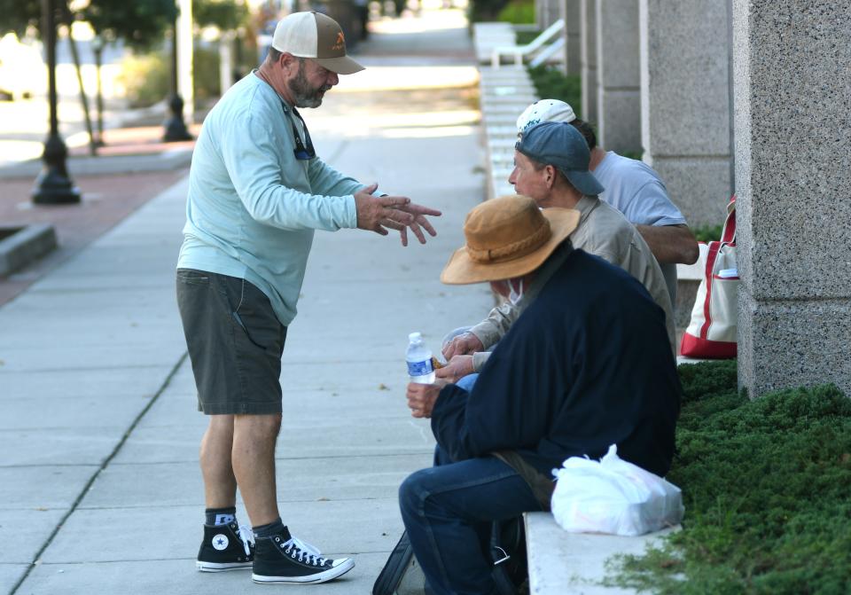 Rick Stoker, CEO of First Fruit Ministries, checks in on members of the homeless community in front of the library in downtown Wilmington in 2021.