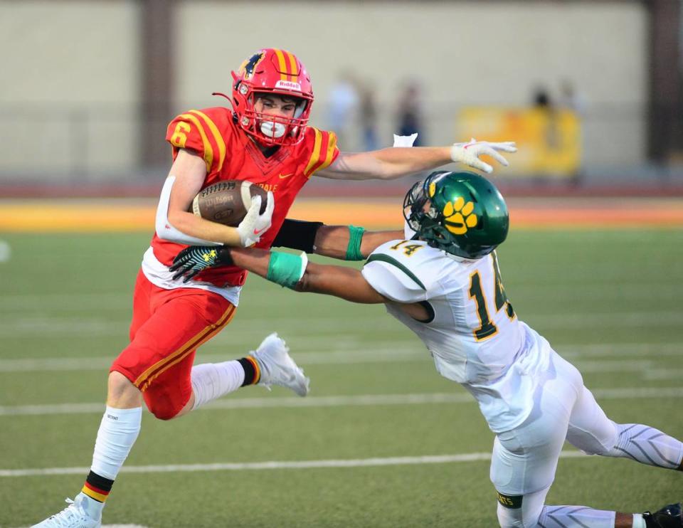 Oakdale running back Chase Lopez stiff arms a defender during a game between Oakdale High School and Sonora High School at Oakdale High School in Oakdale California CA on August 18, 2023.