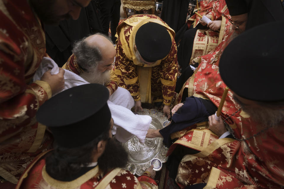 Patriarch Theophilos III, the Greek Orthodox Patriarch of Jerusalem, left, performs the Washing of the Feet ceremony during the Holy Week at the Church of the Holy Sepulcher, where many Christians believe Jesus was crucified, buried and rose from the dead, in Jerusalem's Old City, Thursday, May 2, 2024. (AP Photo/Mahmoud Illean)