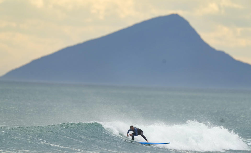 A man surfs at Maresias beach, in Sao Sebastiao, Brazil, Friday, Nov. 26, 2021. Maresias and the surf towns dotting the coastline are inside the Serra do Mar park, which Sao Paulo state says is Brazil’s largest continuous protected area of Atlantic Forest. It acts as a barrier to the urban sprawl of the Sao Paulo metropolitan area. (AP Photo/Andre Penner)