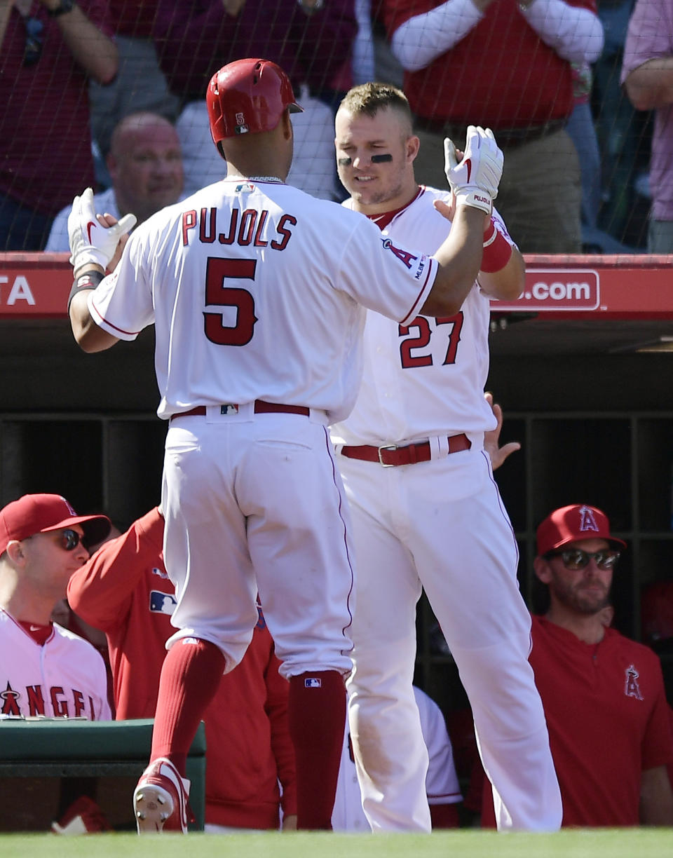 Los Angeles Angels' Albert Pujols, left, is congratulated by Mike Trout after hitting a solo home run during the seventh inning of a baseball game against the Texas Rangers Saturday, April 6, 2019, in Anaheim, Calif. (AP Photo/Mark J. Terrill)