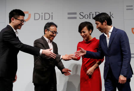 Vice President of Didi Chuxing Stephen Zhu, SoftBank Corp's CEO Ken Miyauchi, President of Didi Chuxing Jean Liu and SoftBank Corp' executive Keigo Sugano shake hands after a news conference about their Japanese taxi-hailing joint venture in Tokyo, Japan, July 19, 2018. REUTERS/Kim Kyung-Hoon