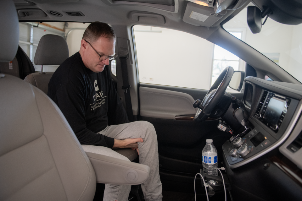Jason Kolb, an Akron doctor who was paralyzed in a skiing accident, situates himself before driving in his modified Toyota Sienna van on a recent afternoon. The van operates with hand controls.