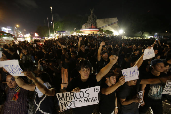 FILE - Demonstrators hold slogans as they gather at the People's Power Monument in Quezon city, north of Manila Philippines Friday, Nov. 18, 2016, to protest against the burial of the late dictator Ferdinand Marcos. Filipino Filipino voters overwhelmingly elected Ferdinand "Bongbong" Marcos Jr., as president during the May 2022 elections, completing a stunning return to power for the family of the late President Ferdinand Marcos, Sr., who ruled the country for more than two decades until being ousted in 1986 in the nonviolent "People Power" revolution. (AP Photo/Aaron Favila, File)