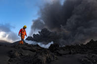 A scientist from IGME-CSIC (Geological and Mining Institute of Spain from Spanish National Research Council) walks near a volcano on the Canary island of La Palma, Spain, Sunday, Nov. 5, 2021. Scientists from around the world flocking to an eastern Atlantic Ocean island are using an array of new technologies available to them in 2021 to scrutinize — from land, sea, air, and even space — a rare volcanic eruption. (AP Photo/Taner Orribo)