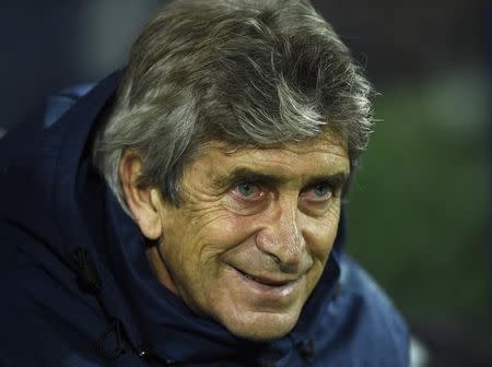 Manchester City manager Manuel Pellegrini smiles before the start of their English Premier League soccer match against Queens Park Rangers at Loftus Road in London November 8, 2014. REUTERS/Dylan Martinez