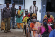 People wait to receive the vaccine for COVID-19 at a vaccination center set up at a government run school in Bengaluru, India, Tuesday, Sept. 21, 2021. India, the world's largest vaccine producer, will resume exports and donations of surplus coronavirus vaccines in October after halting them during a devastating surge in domestic infections in April, the health minister said Monday. (AP Photo/Aijaz Rahi)