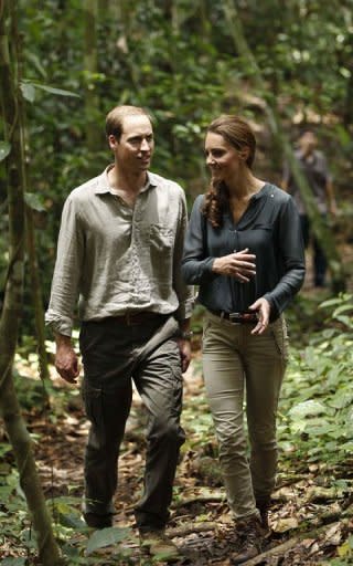 Prince William (L) and his wife Catherine, the Duchess of Cambridge, walk through the rainforest in Danum Valley Research Center on the island of Borneo on September 15