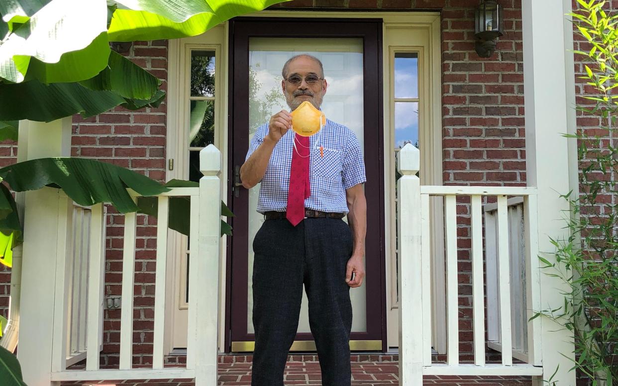 Peter Tsai holding up an N95 face mask - Peter Tsai