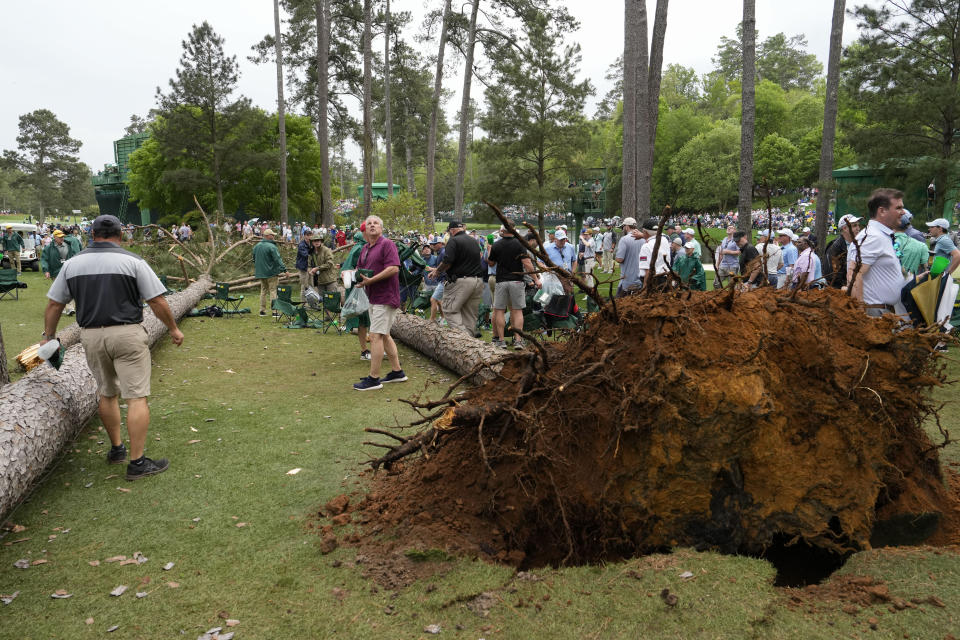 Patrons move away from two trees that blew over on the 17th hole during the second round of the Masters golf tournament at Augusta National Golf Club on Friday, April 7, 2023, in Augusta, Ga. (AP Photo/Mark Baker)