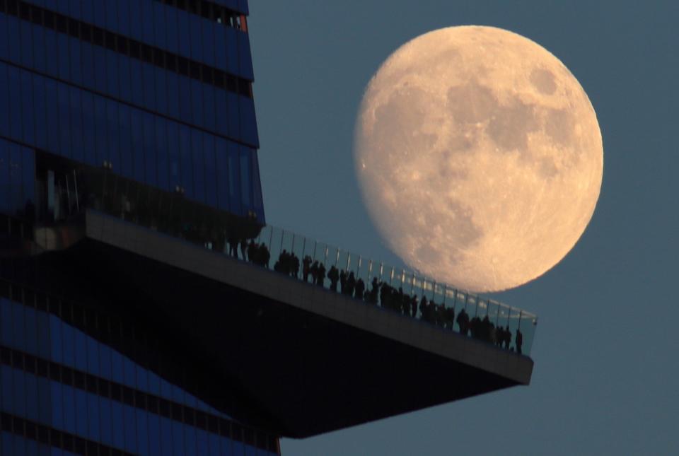 HOBOKEN, NJ - NOVEMBER 16: A 94 percent illuminated waxing gibbous moon rises behind the EdgeNYC outdoor observation deck at Hudson Yards in New York City on November 16, 2021, as seen from Hoboken, New Jersey. A lunar eclipse of the full Beaver Moon will be seen in North America early Friday morning.
