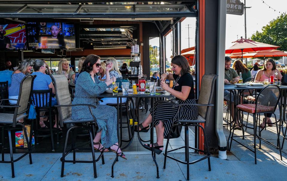 Kisti Bodell of Lansing, left, and Ricky McHooven from Grand Rapids enjoy their meal in the outdoor covered patio at One North Kitchen and Bar in Delta Township Thursday, Aug. 10, 2023.