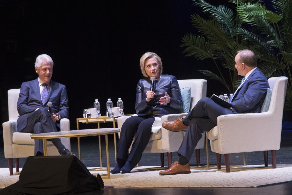 Former President Bill Clinton, left, and Paul Begala, right, listen and former Secretary of State Hillary Rodham Clinton speaks during "An Evening with the Clintons", Thursday, April 11, 2019, at the Beacon Theatre in New York. (AP Photo/Mary Altaffer)