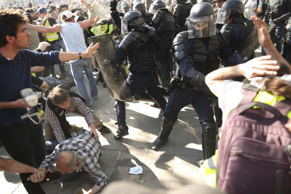 Police scuffle with protestors during a yellow vest demonstration in Paris, Saturday, April 20, 2019. French yellow vest protesters are marching anew to remind the government that rebuilding the fire-ravaged Notre Dame Cathedral isn't the only problem the nation needs to solve. (AP Photo/Francisco Seco)