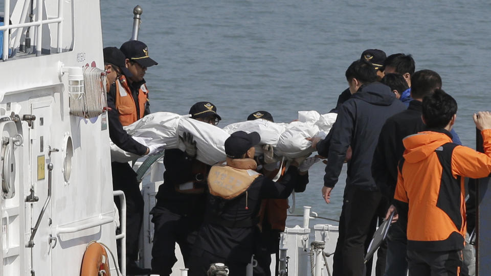 Socorristas cargan el cadáver de un pasajero que iba a bordo del ferry hundido en las costas de Corea del Sur, en el puerto de Jindo, el 20 de abril de 2014. El Sewol se hundió el miércoles con 476 personas a bordo, la mayoría jóvenes estudiantes, y sólo hay 174 sobrevivientes. (Foto AP/Lee Jin-man)
