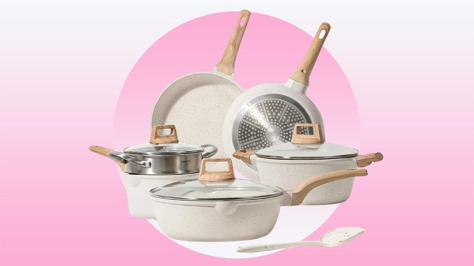 The white Carote cookware set on a pink background. 