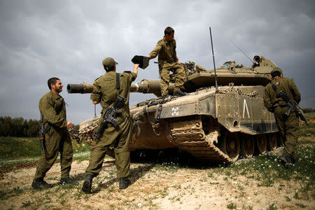 Israeli soldiers are seen next to a tank, near Israel's border with the central Gaza Strip February 28, 2017. REUTERS/Amir Cohen