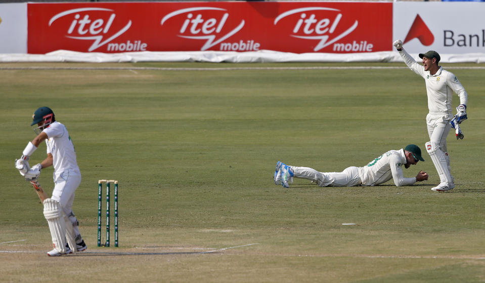 South Africa's Quinton de Kock, right, and Faf du Plessis, center, react after the dismissal of Pakistan's batsman Mohammad Rizwan, during the second day of the first cricket test match between Pakistan and South Africa at the National Stadium, in Karachi, Pakistan, Wednesday, Jan. 27, 2021. (AP Photo/Anjum Naveed)