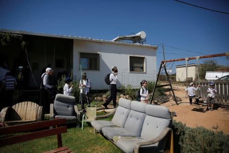 Visitors walk in a yard near a home in the Jewish settler outpost of Amona in the West Bank, during an event organised to show support for Amona which was built without Israeli state authorisation and which Israel's high court ruled must be evacuated and demolished by the end of the year as it is built on privately-owned Palestinian land, October 20, 2016. REUTERS/Ronen Zvulun/File Photo