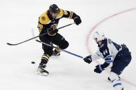 Winnipeg Jets' Josh Morrissey (44) battles Boston Bruins' David Pastrnak (88) for the puck during the third period of an NHL hockey game, Saturday, Jan. 22, 2022, in Boston. (AP Photo/Michael Dwyer)