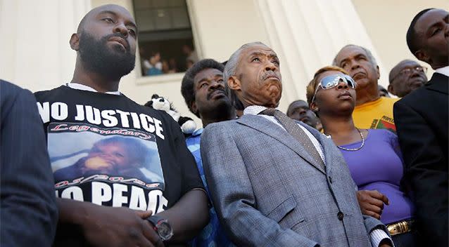 Civil rights leader Rev. Al Sharpton (centre) stands with the parents of Michael Brown, Lesley McSpadden (right) and Michael Brown Sr (left) during a news conference outside the Old Courthouse. Photo: AP.